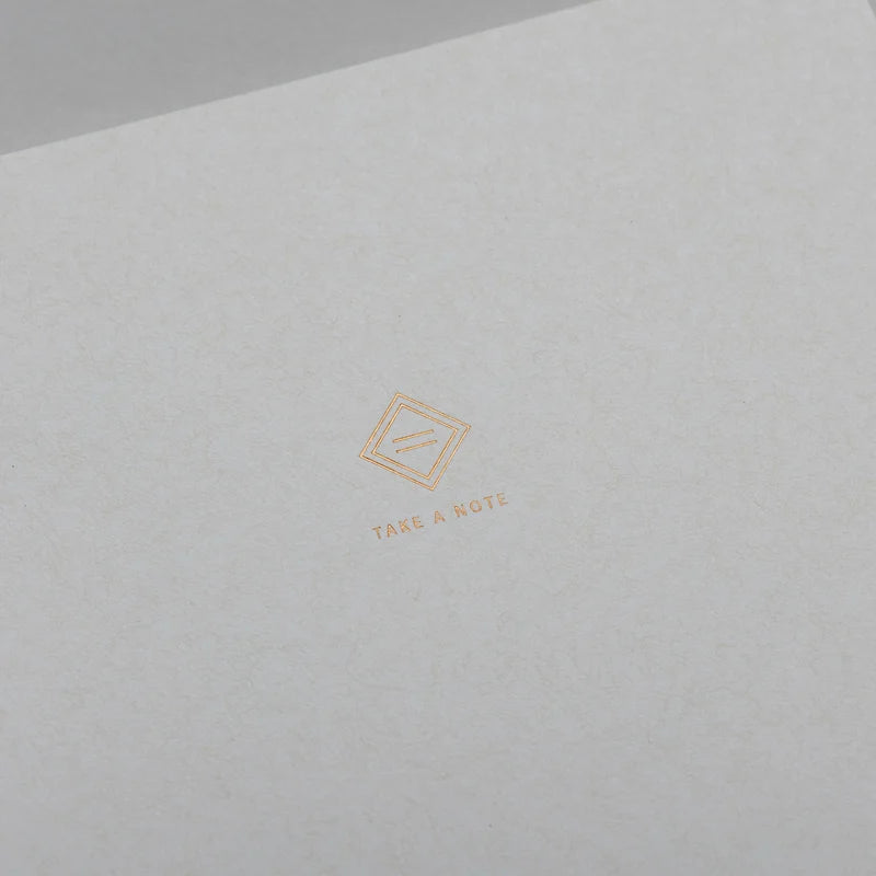 2027 Regular Planner A5 by Take a Note — close-up of the textured cover with gold-foil Take a Note logo, for journaling
