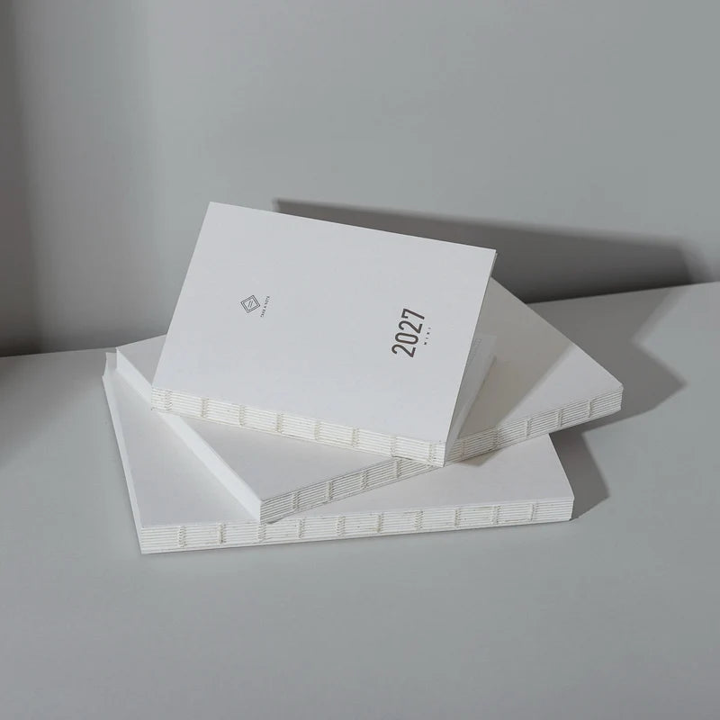 2027 Mini Planner A6 by Take a Note — stacked white planners with gold-foil 2027, for planning