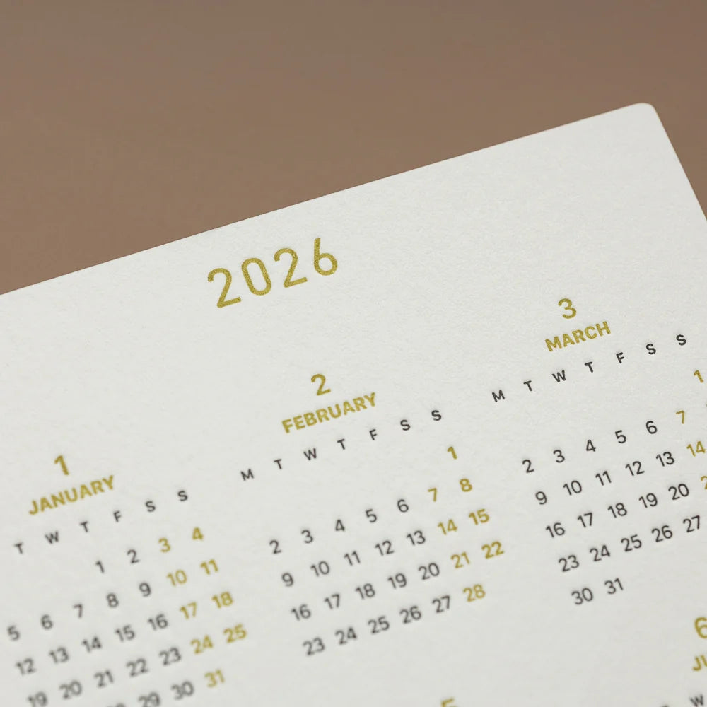 Calendar for 2026 on a white surface with a brown background