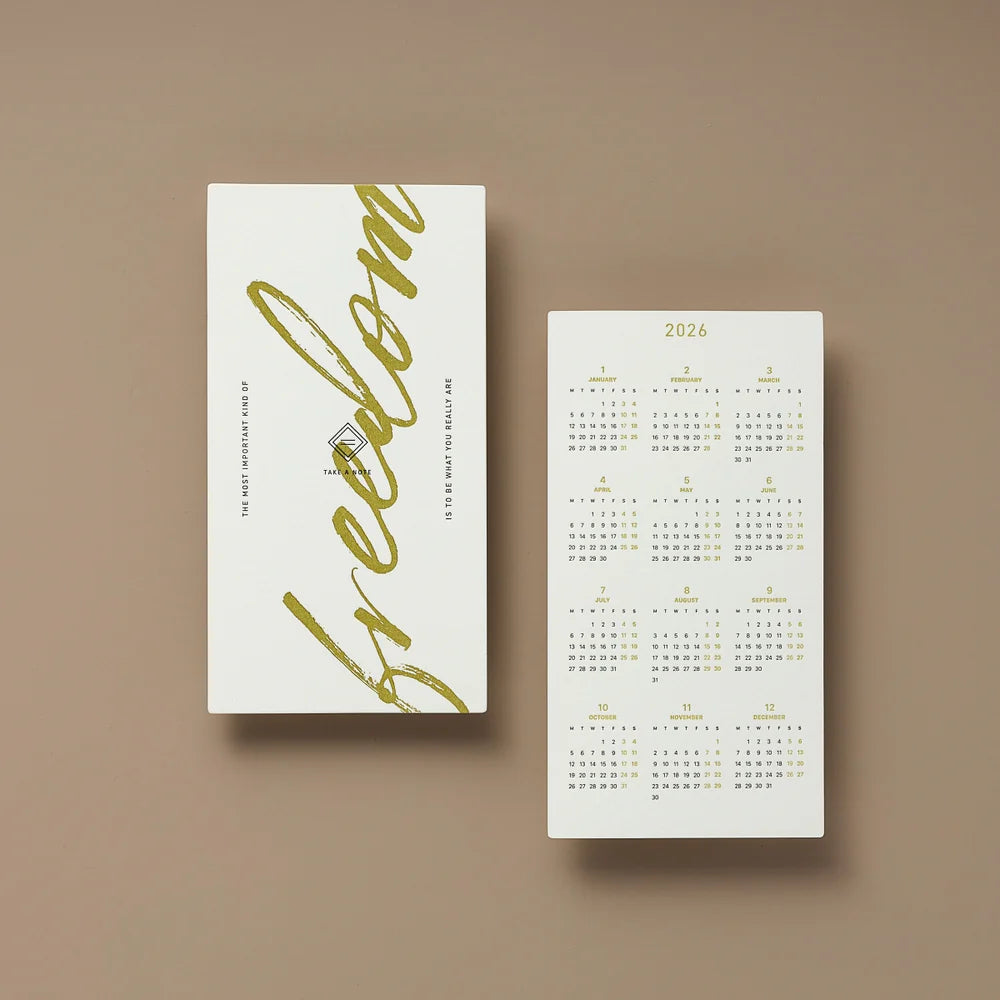 Two white calendars with gold text on a brown background