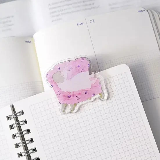 Sofa Journaling Clip by Dodolulu — pink sleeping-sheep acrylic clip on a grid notebook, for journaling