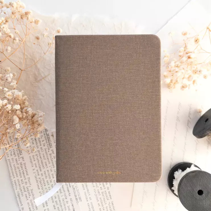A6 Blank Notebook in textured brown styled with dried flowers on a light surface