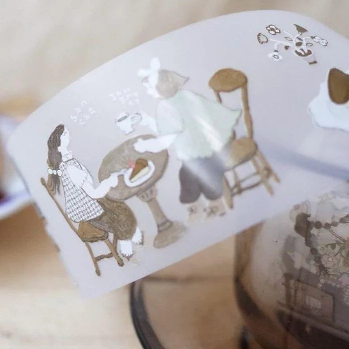 Roll of Afternoon Tea PET Tape with cafe figures and furniture unrolled on a warm wooden surface