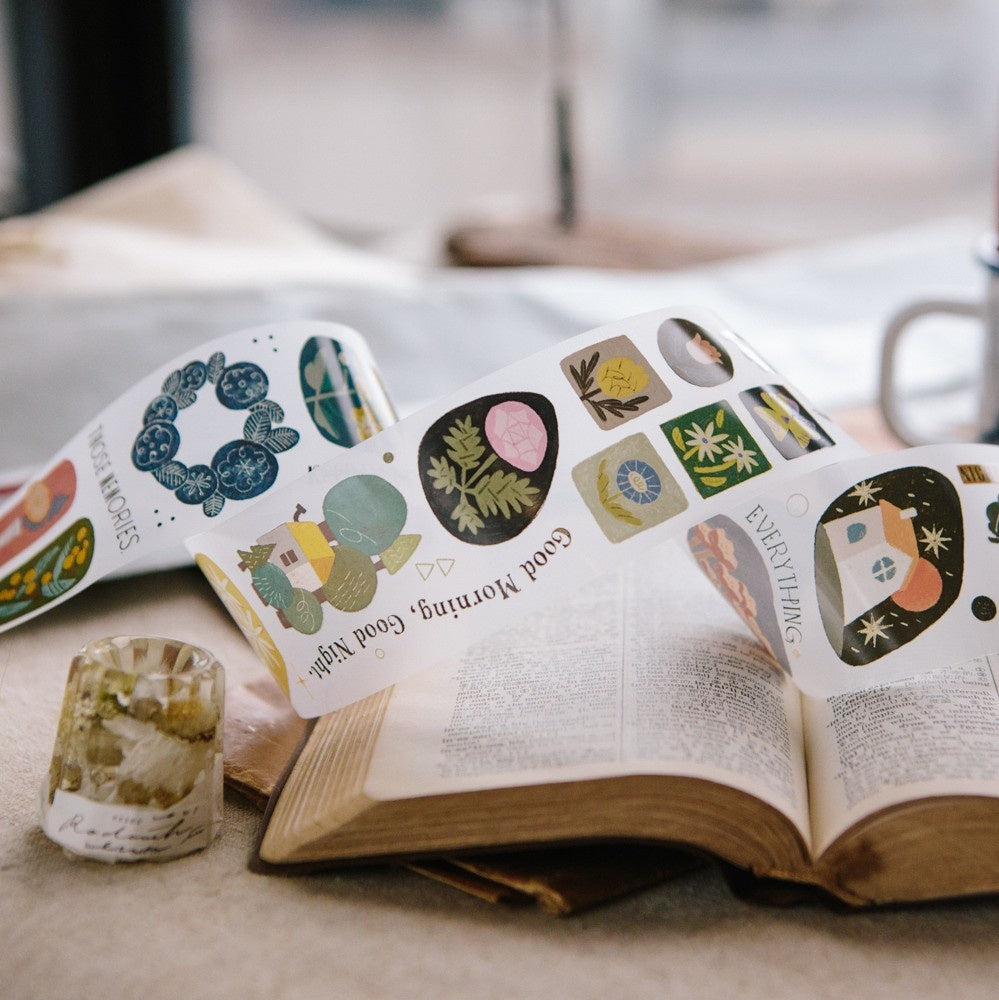 Open book with decorative stickers on a surface