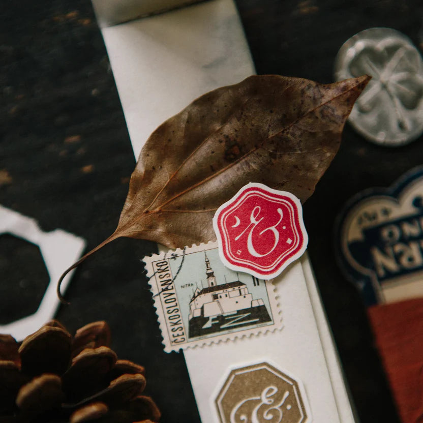 Ampersand Letterpress Memo Pad box with red and white logo, leaf and pine cone on dark