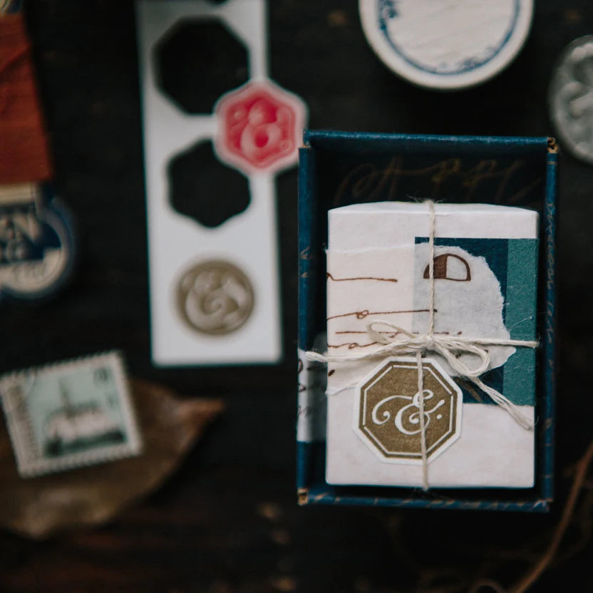 Decorative stationery items with stamps and a small box on a dark background