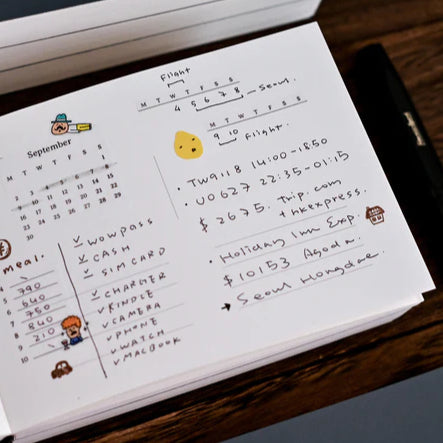 Open Anytime Anywhere Journal spread with handwritten notes and a monthly calendar layout, top view on a wooden surface