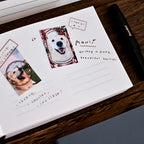 Notebook with dog photos and text on a wooden surface