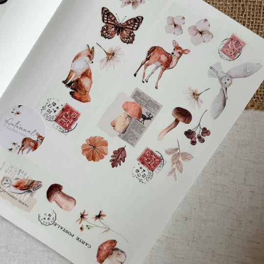 Sheet of decorative stickers with animals, flowers, and stamps on a textured surface.