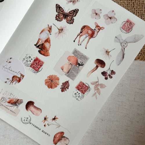 Sheet of decorative stickers with animals, flowers, and stamps on a textured surface.