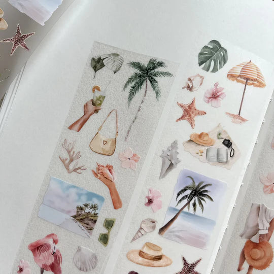 Beach Day PET Tape coastal designs with palm trees, shells and beach scenes laid out on a white surface