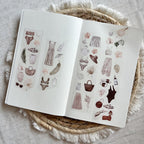 Open book with illustrated fashion designs on a textured surface
