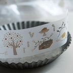 Decorative ribbon with illustrations on a metal cake pan