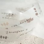 Textured paper with motivational phrases and floral designs on a light background