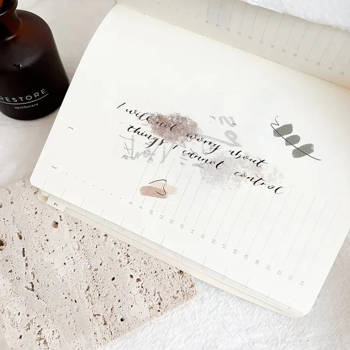 Open notebook decorated with an Attic Calligraphy Spiritual Quote PET Tape phrase, styled craft flat lay