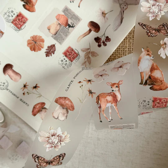 Autumnal PET Tape designs including deer, mushrooms and butterflies laid out on a textured craft surface
