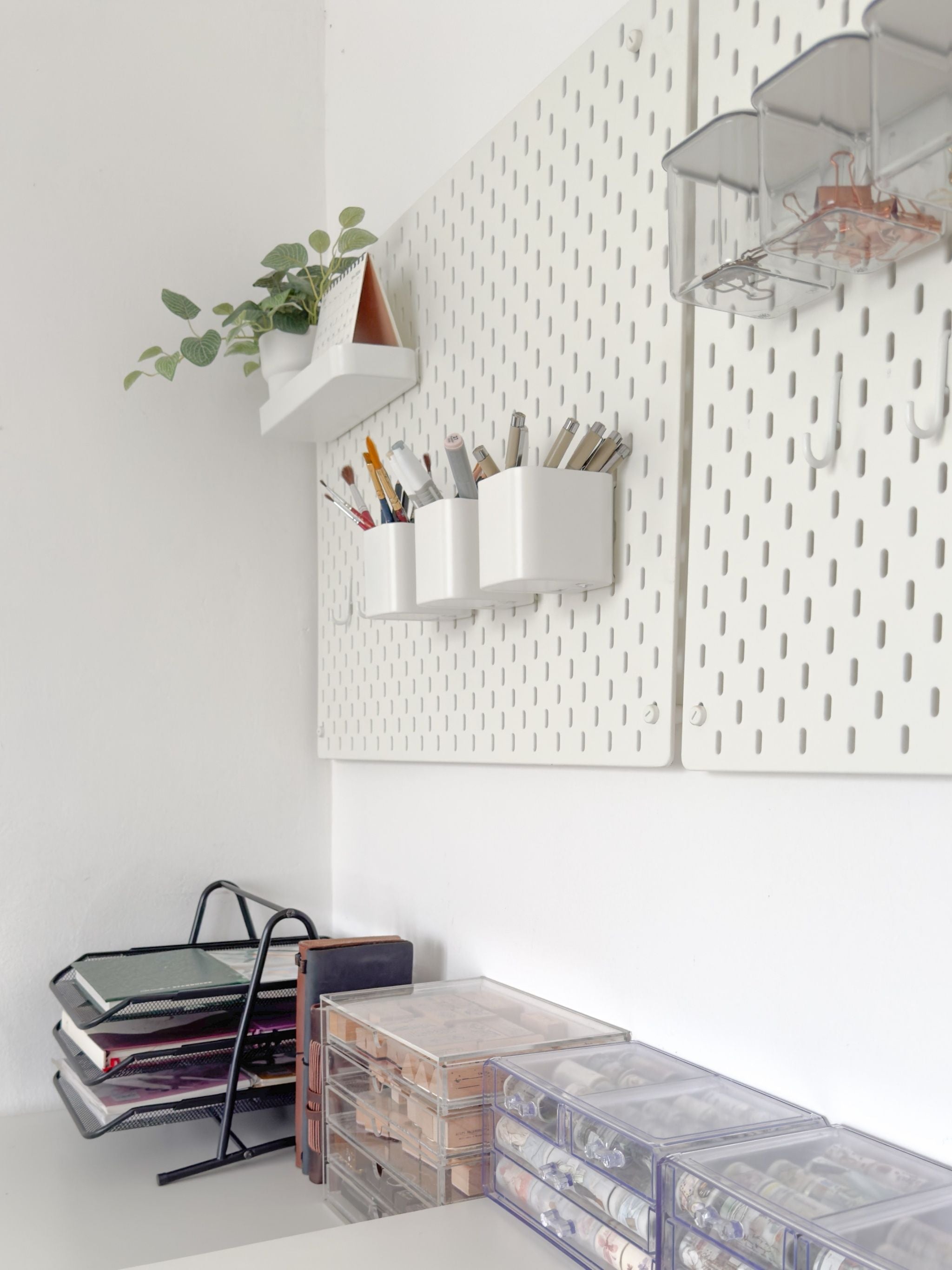 Wall-mounted storage solutions with shelves and containers in a minimalistic room.