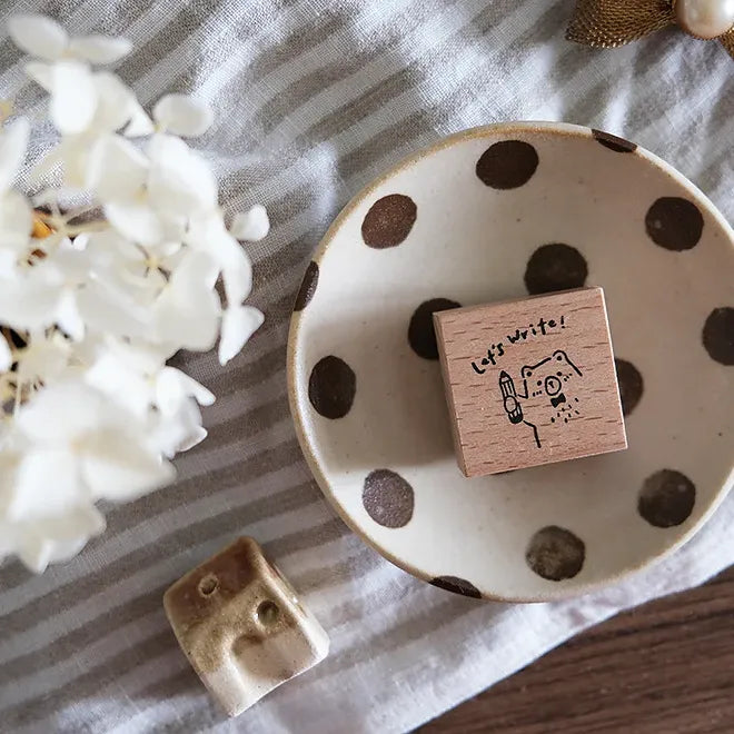 Polka dot dish with wooden block and ceramic piece on striped fabric