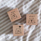 Three wooden rubber stamps with bear illustrations on a striped fabric background