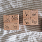 Set of wooden stamps with bear illustrations and text on a striped fabric background