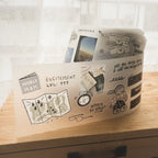 Storage bin with travel-themed illustrations on a wooden surface