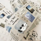 Decorative paper with travel-themed stickers and text on a white background