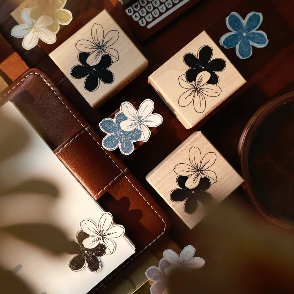 Bicolor Flowers Rubber Stamp by Yier flower-shaped maple stamps on a desk with a coffee cup