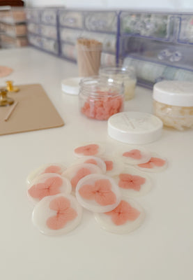 Pink flower-shaped objects on a white surface with a blurred background
