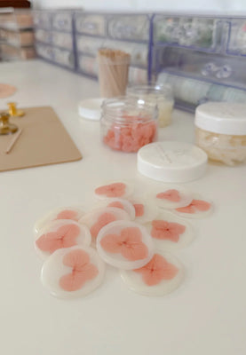 Decorative coasters with pink floral designs on a white surface.