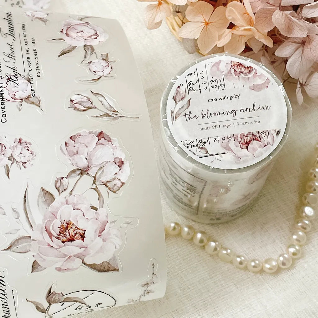 Candle and packaging decorated with Blooming Archive PET Tape florals on a light background