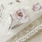 Floral stickers with pink flowers and green leaves on a textured beige background