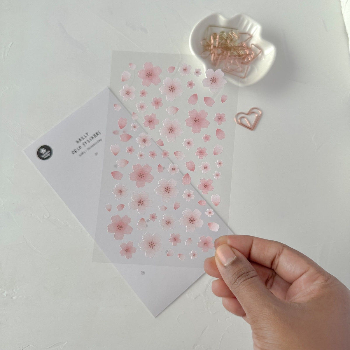 Hand holding a sheet of pink floral stickers, from the Blossom Day Sticker Sheet