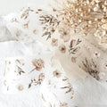 Floral-patterned fabric with dried flowers on a light background