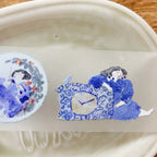 Detailed view of blue-themed sticker strip with girl illustration holding a polka dot pot on translucent background