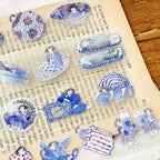 Close-up of blue floral teapot illustration sticker on transparent PET tape with soft pastel detailing