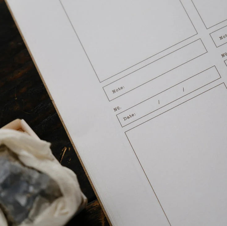 Brick Notes Notebook inner pages showing the four-square printed layout on a wooden desk