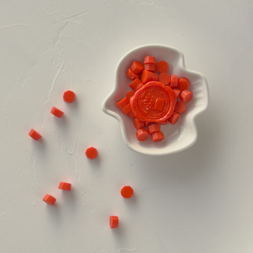 Red candy pieces with a central mold on a white background