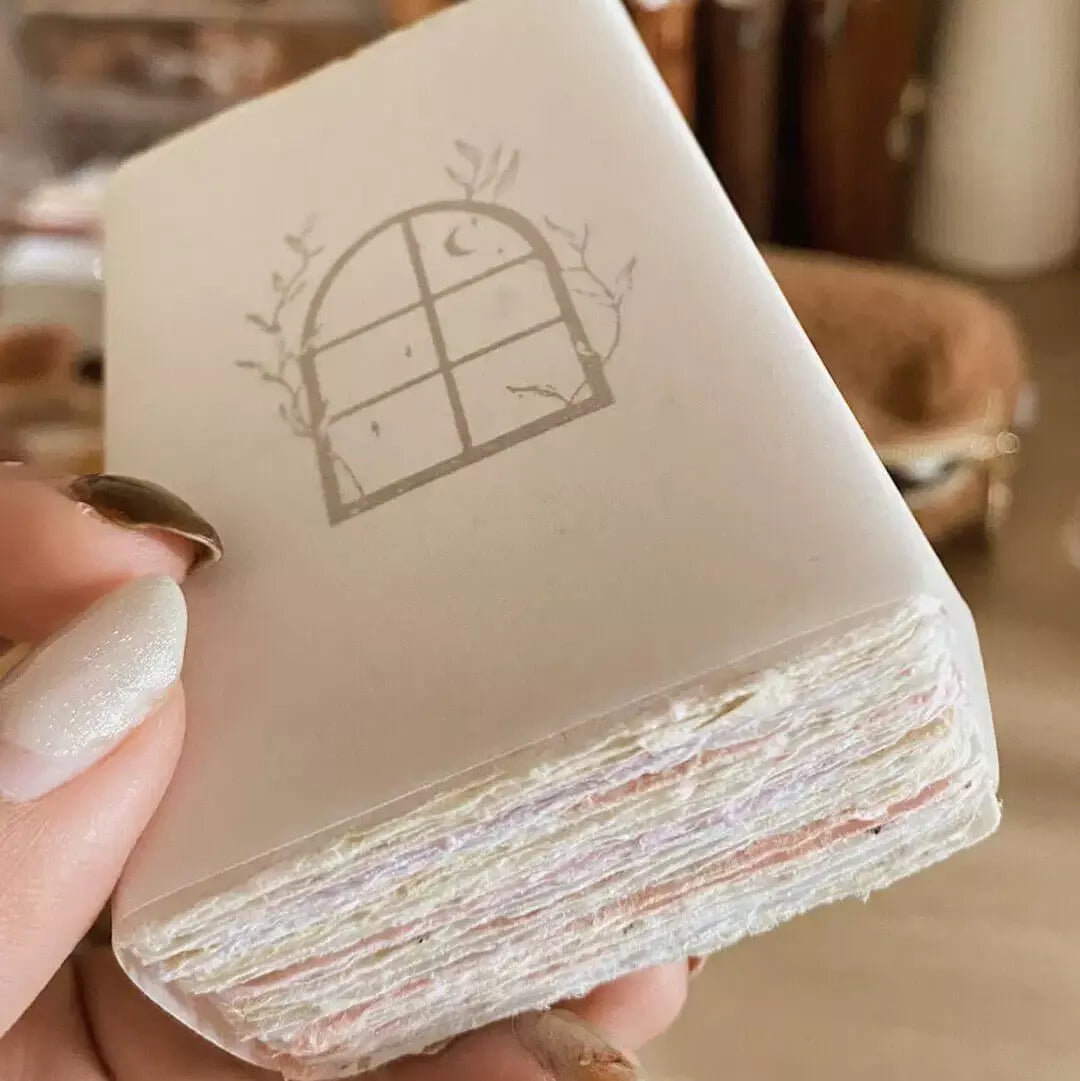 Hand holding a layered stack of Handmade Paper Business Cards with a window design on top