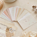 Set of sample papers with different textures and colors on a light surface.