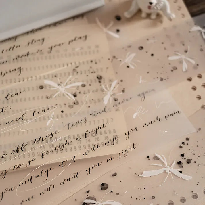 Butterfly PET Tape butterflies styled over vintage sheet music on a warm beige background, flat lay