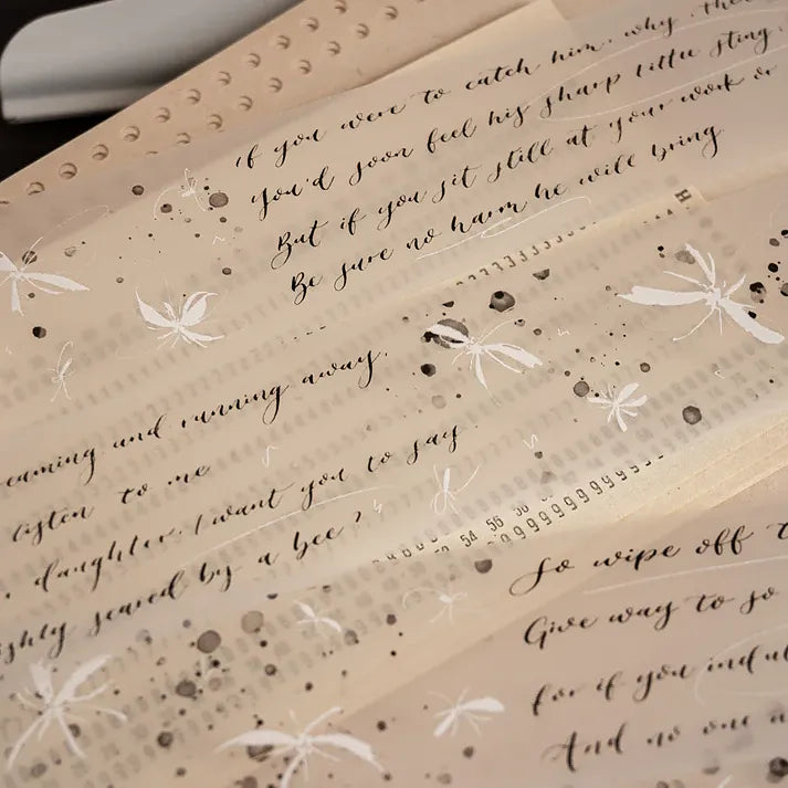 Close-up of a book page decorated with Butterfly PET Tape white butterflies and script patterns
