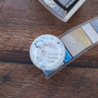 Round photo album with 'Camera Roll Favorites Folder' text on a wooden surface