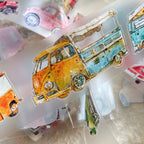 Colorful vintage van stickers on a reflective surface