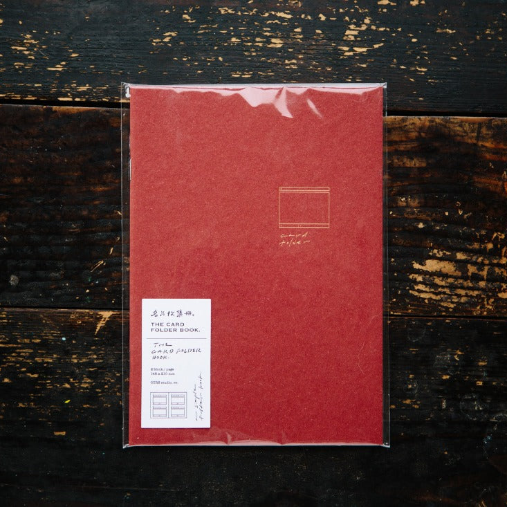 Red notebook with a label on a dark wooden surface