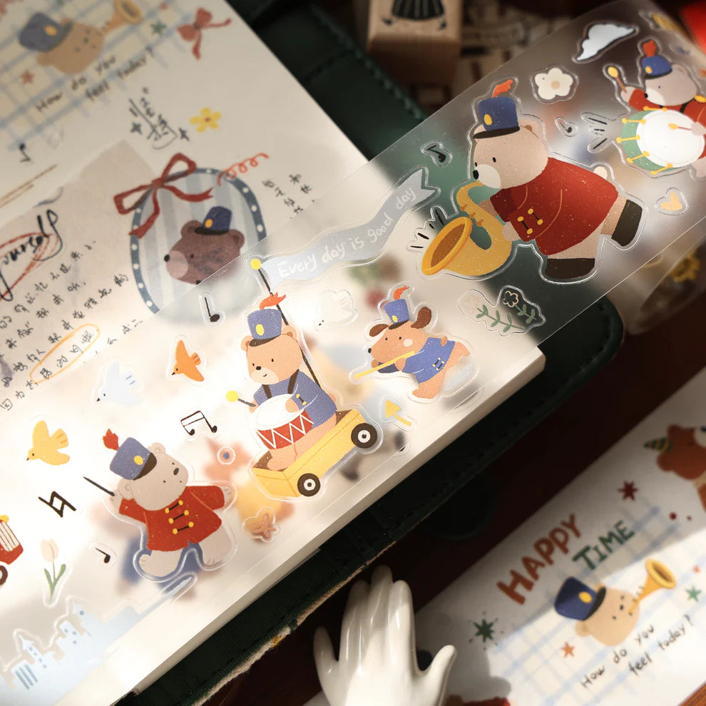 Roll of Carols of Joy PET Tape by Yier with cartoon bear designs and text resting on a notebook