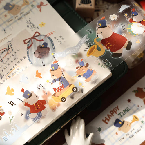 Roll of Carols of Joy PET Tape by Yier with cartoon bear designs and text resting on a notebook
