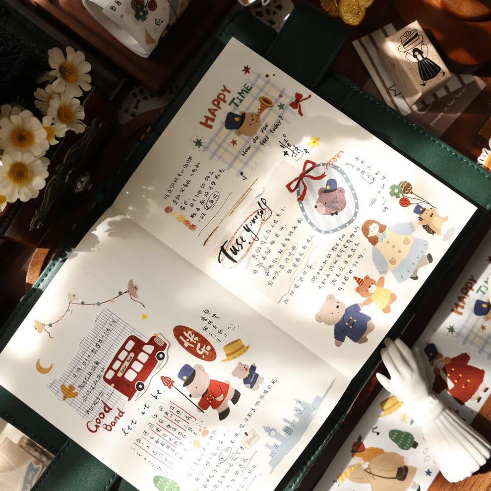 Open book decorated with Carols of Joy PET Tape festive illustrations on a wooden surface