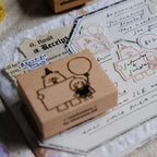 Small brown box with a bear design on a surface with handwritten text