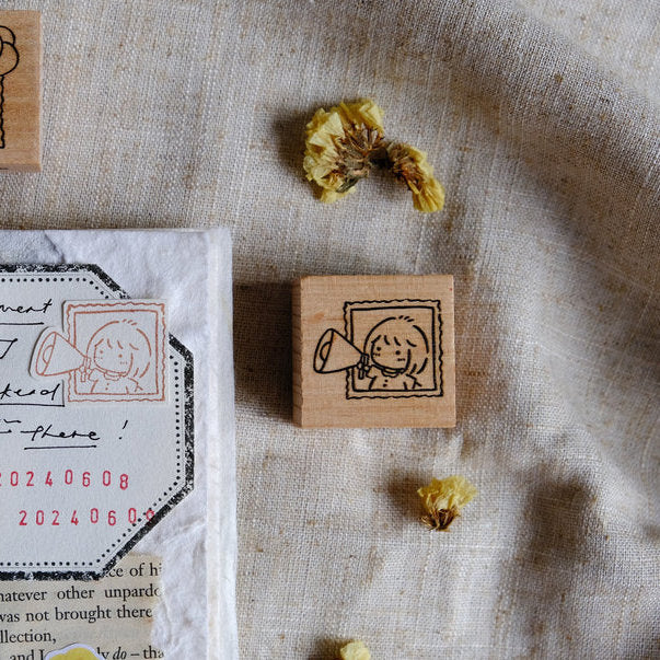 Celebration Rubber Stamp with a figure holding a megaphone design on textured fabric