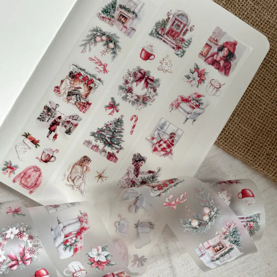 Sheet of Christmas Cheer PET Tape festive sticker designs arranged on a textured craft surface